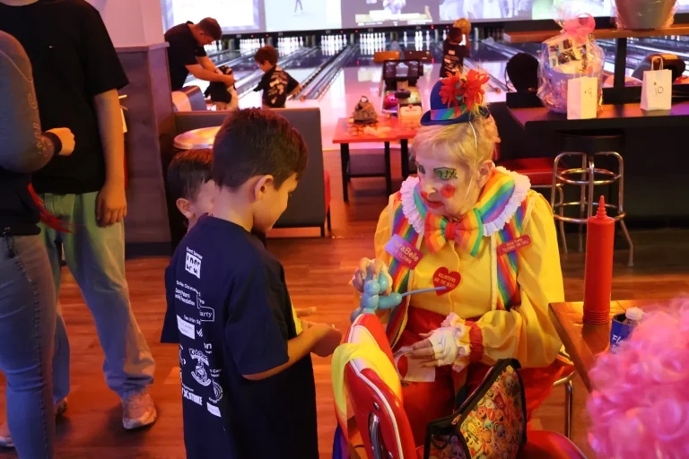 A clown making balloon animals for the children