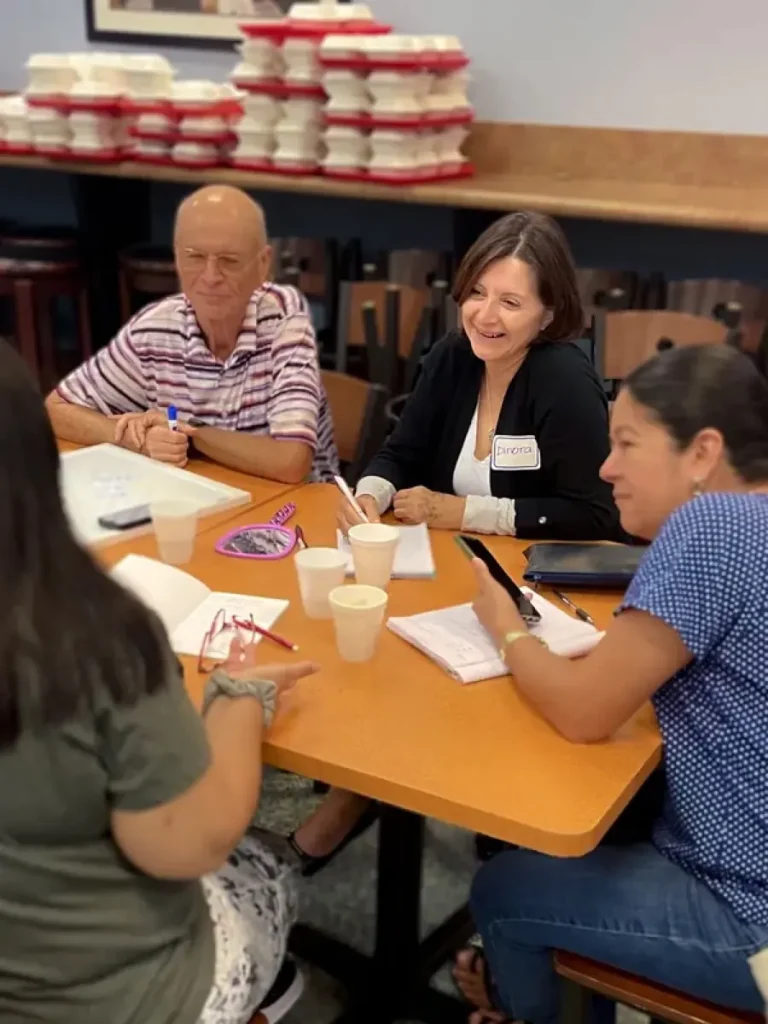 ESOL Conversation Café participants talking around a table