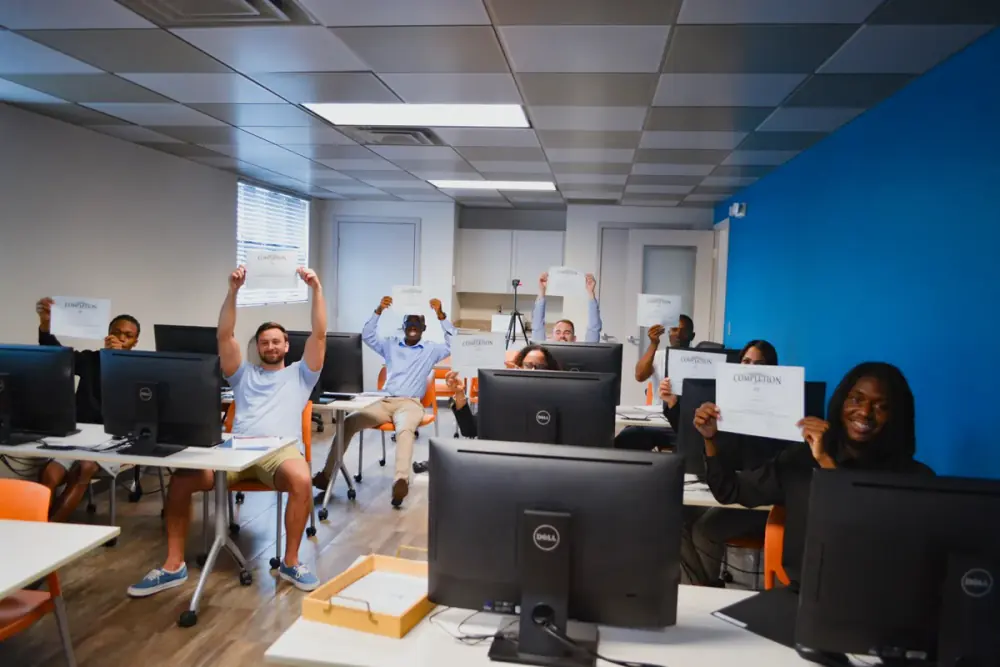 Workforce Development students celebrating with their certificates in a computer lab
