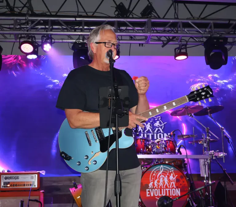 A guitarist singing under the stage lights at Rock the Relief