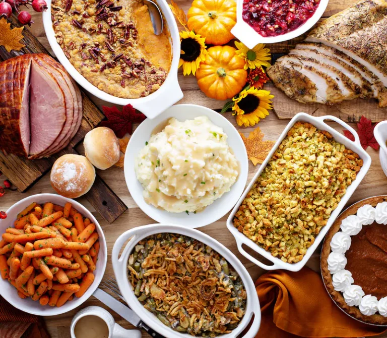 A Thanksgiving table set with turkey, sides and pies