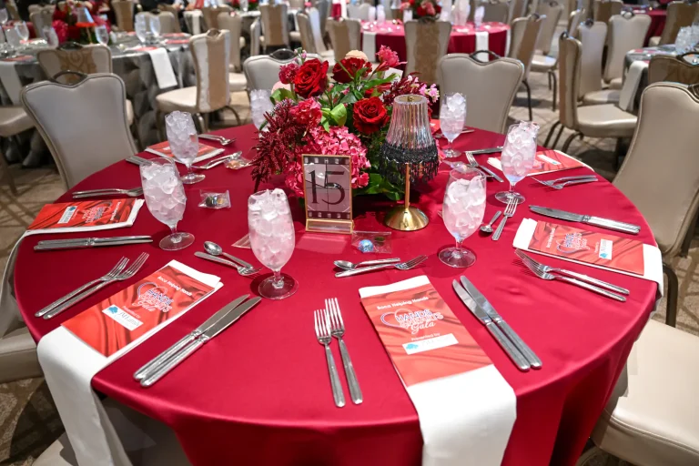 A gala table set in red with place cards and candles