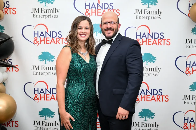A couple photographed at the Hands & Hearts step-and-repeat