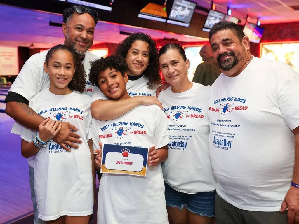 A family in Boca Helping Hands Bowling for Bread T-shirts at the alley