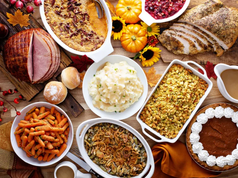 A Thanksgiving table set with turkey, sides and pies