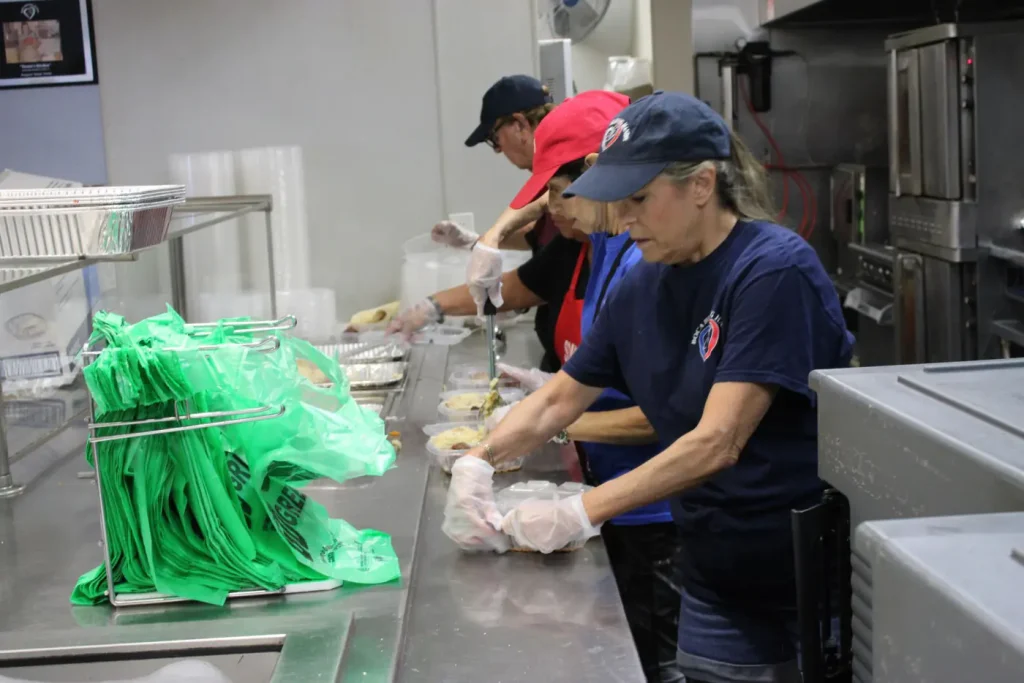 Volunteers preparing hot meals in the Boca Helping Hands kitchen