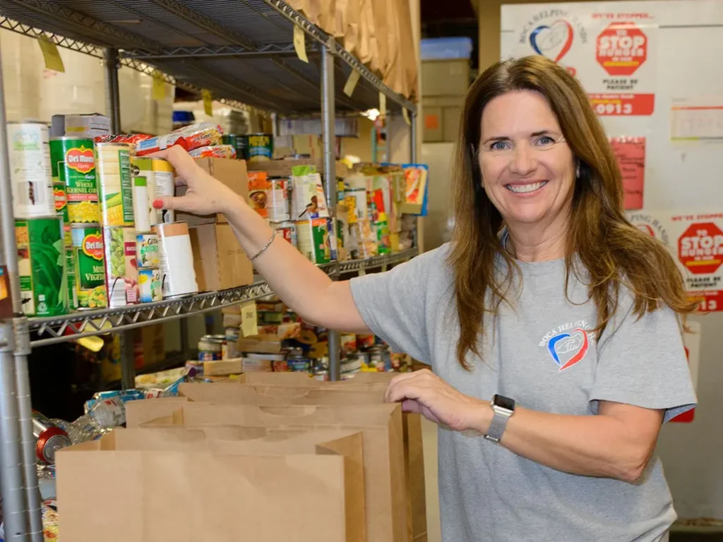Volunteer packing a paper pantry bag with groceries
