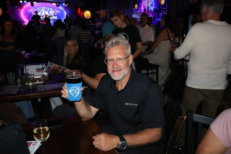 A guest raising his glass to the camera