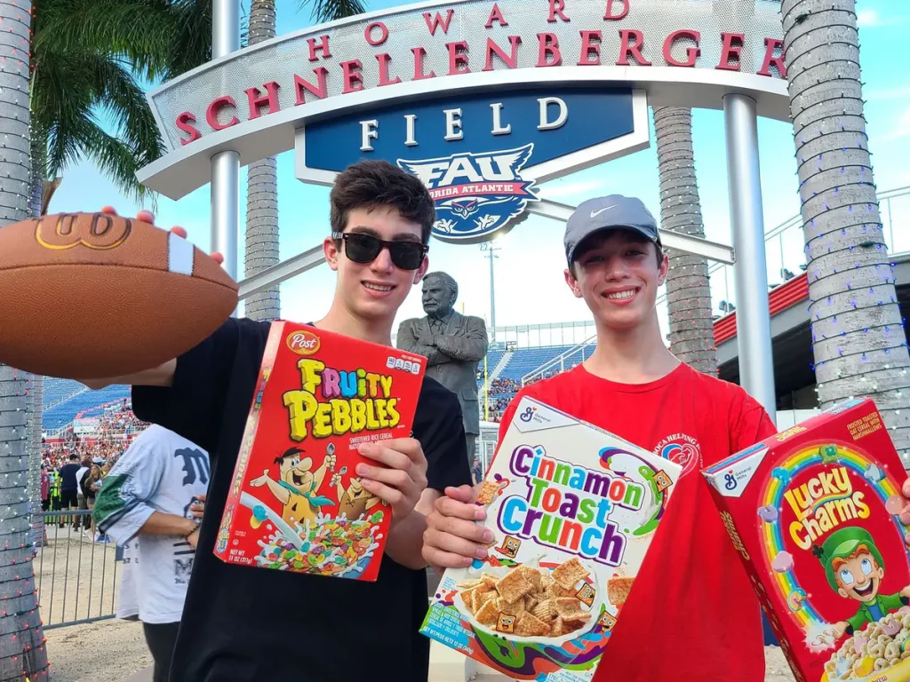 Twin brothers Jett and Luke Justin holding cereal boxes at the FAU stadium
