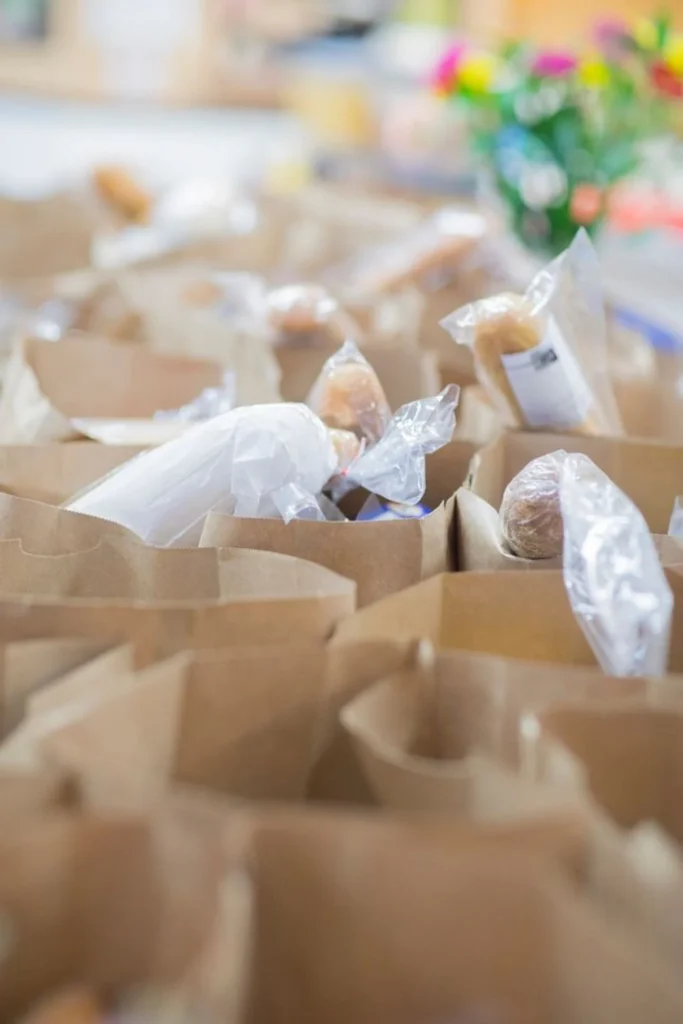 Volunteer packing a paper pantry bag with groceries