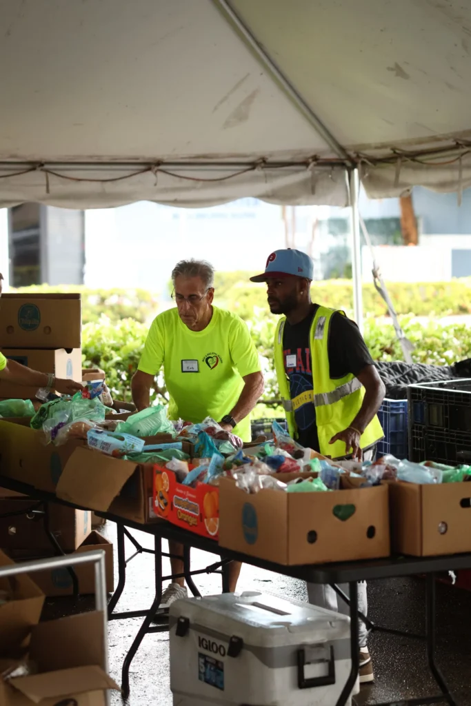 A bag of groceries being handed from one person to another