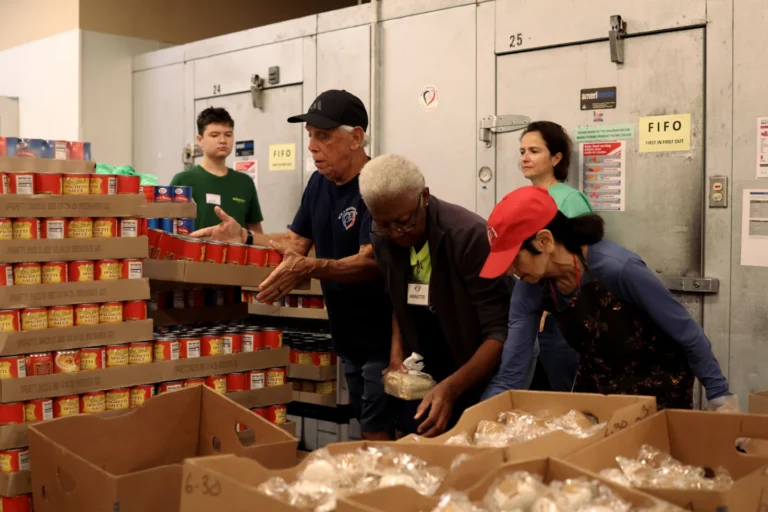 Volunteer loading groceries into a client's car